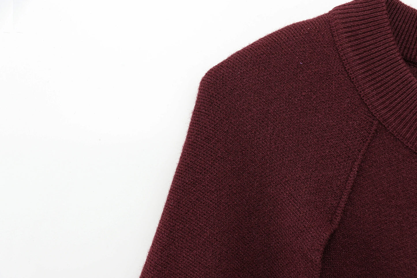 Close-up of a burgundy cape on a white background