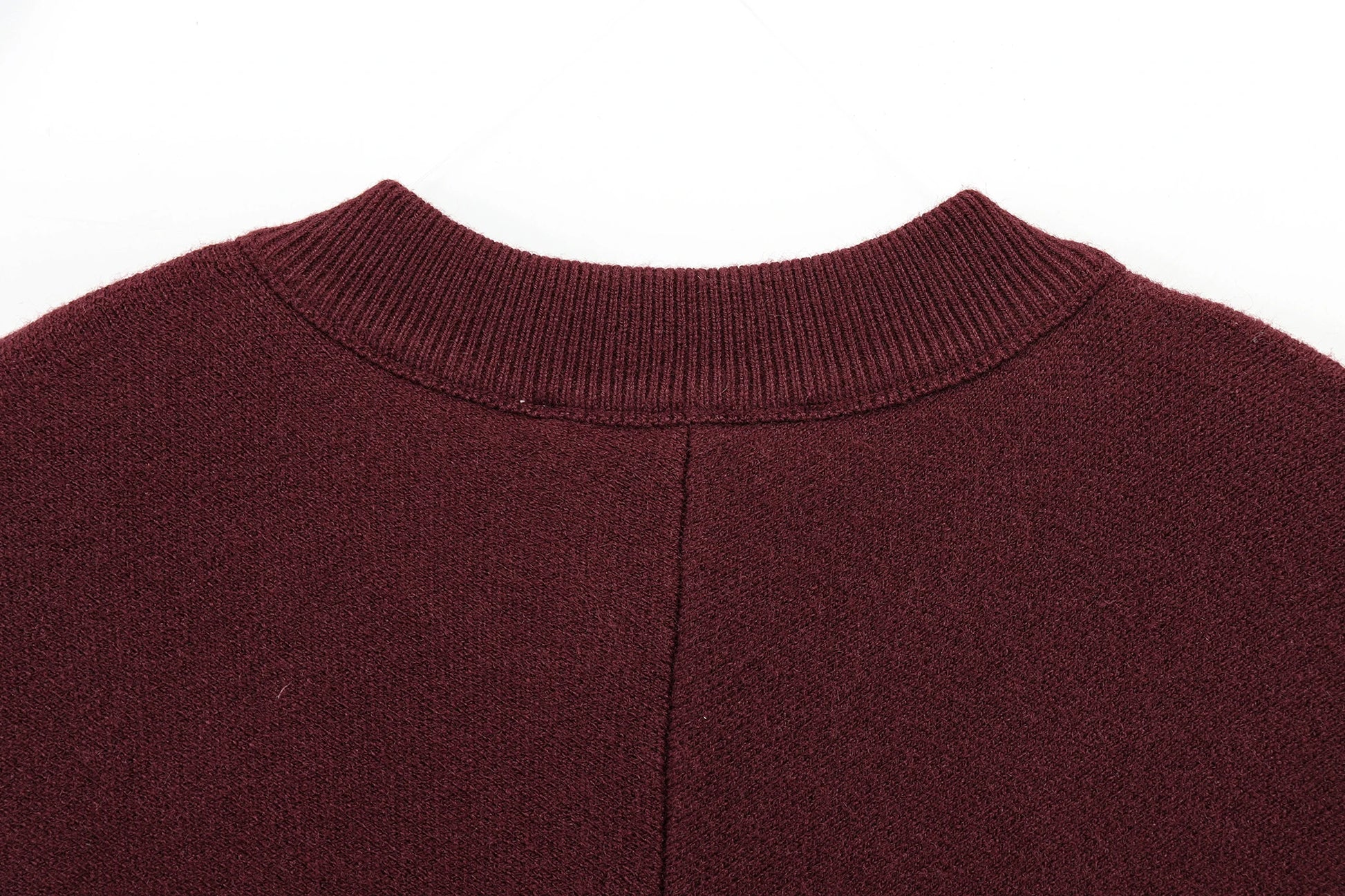 Close-up of a burgundy cape with a ribbed neckline on a white background