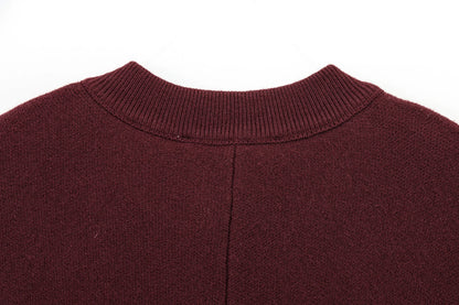 Close-up of a burgundy cape with a ribbed neckline on a white background