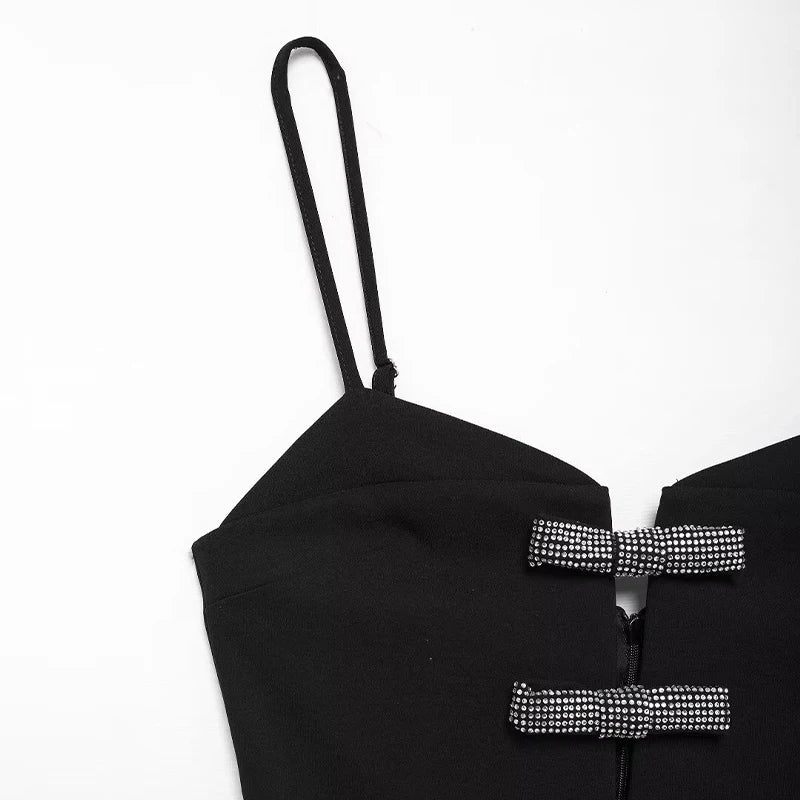 Elegant black mini dress styled for festive occasions, featuring diamond bow details.