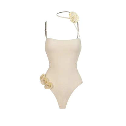 Beige one-piece swimsuit with floral details on a white background