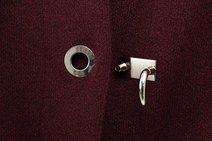 Close-up of a silver lock button on a burgundy cape