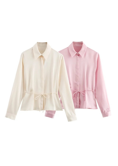 Two shirts, one cream and one pink, on a white background