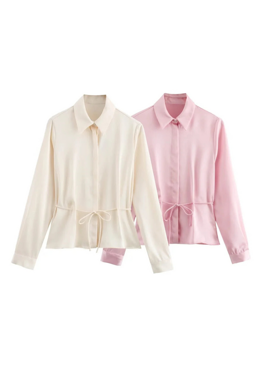Two shirts, one cream and one pink, on a white background