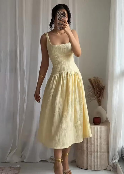 Chic butter yellow midi dress with pleats, square neckline, and open back 